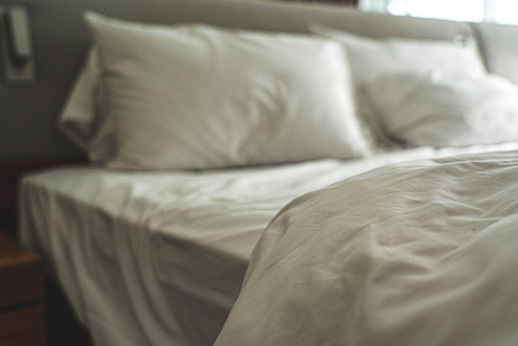 White bedding layered with soft textured blankets and pillows